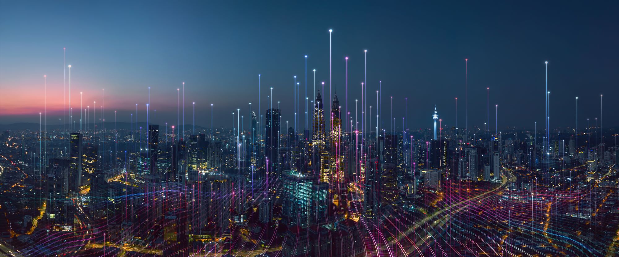 Cityscape lit up with lights at nighttime with an overlay of technology connection points rising into the air