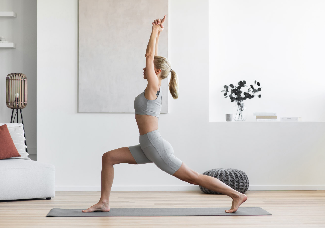 Middled-aged woman doing yoga in her living room